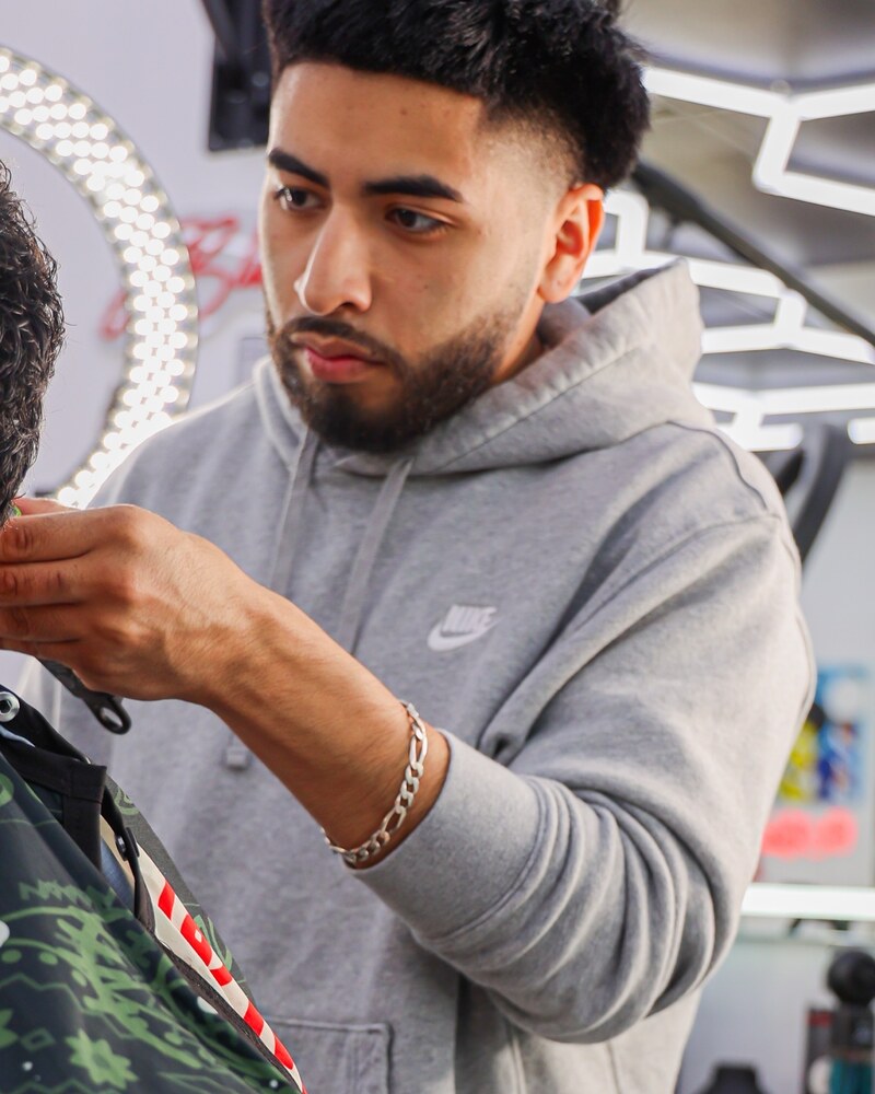 J blendz cutting a client at Plugged N Empire
